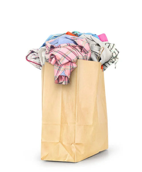 Una bolsa de papel llena de ropa aislada sobre un fondo blanco —  Fotos de Stock