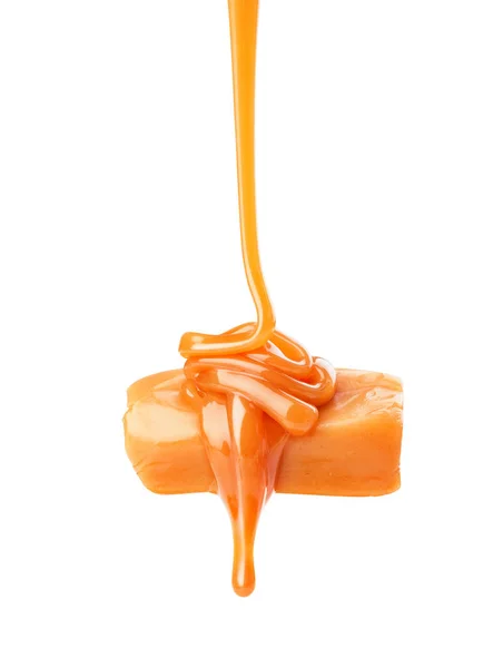 Liquid flowing caramel with candy on a white background — Stock Photo, Image