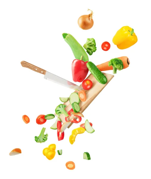 Las verduras caen en el tablero y se cortan con un cuchillo aislado en wh — Foto de Stock