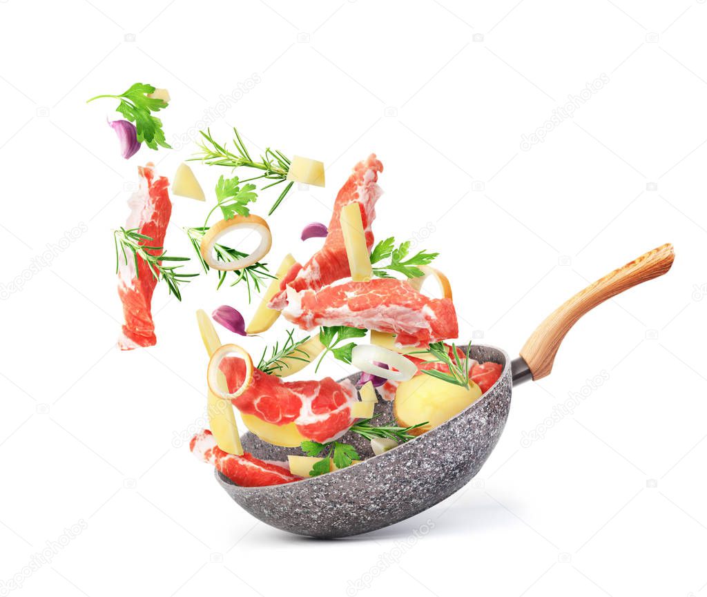 Cooking concept. Vegetables and meat are flying out of the pan i