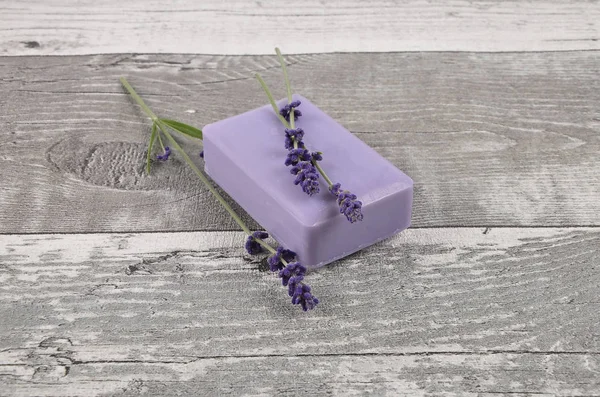 Sabão e lavanda sobre madeira desgastada — Fotografia de Stock