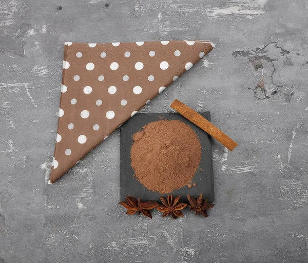 Cocoa powder, cinnamon stick and star anis on concrete — Stock Photo, Image