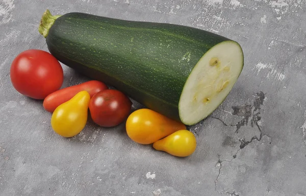 Tomatoes and zucchini on conccrete — Stock Photo, Image