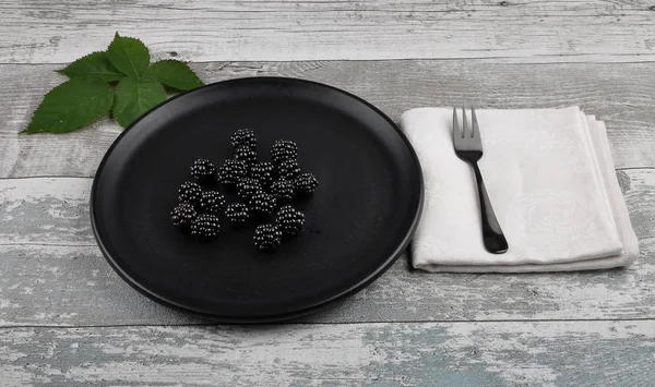 Blackberries on plate and weathered wood — Stock Photo, Image