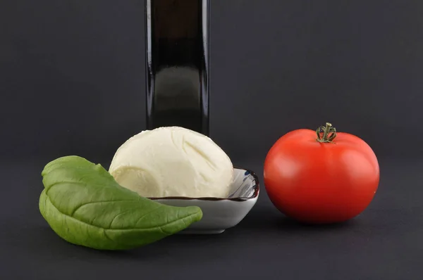 Mozzarella, basilic, huile d'olive et tomate sur noir — Photo