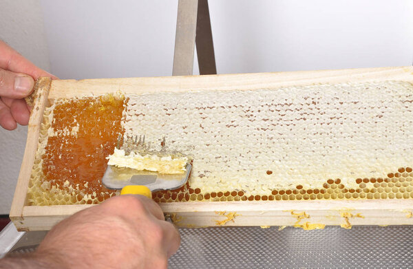 Uncapping of honeycomb at plastic tub 