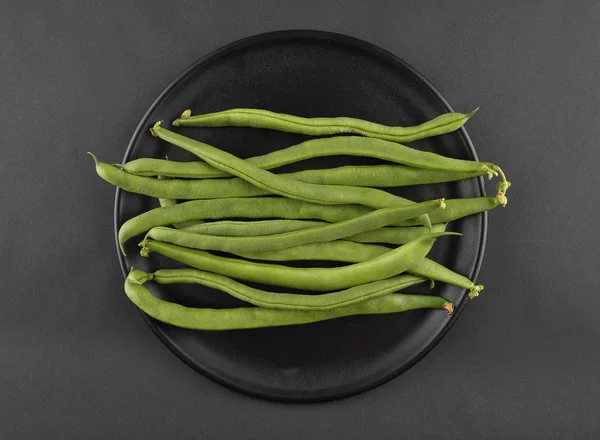 Fagioli su piatto e sfondo nero — Foto Stock