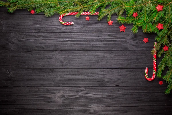 Christmas fir tree on black wooden background — Stock Photo, Image