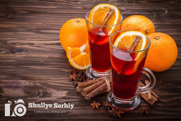 Verre avec vin chaud, épices et fruits sur fond de bois — Photo