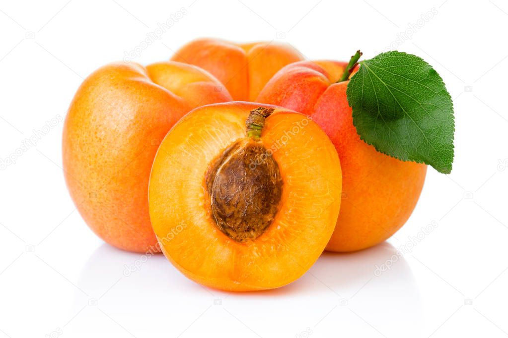 Ripe apricot fruits with with green leaf and slice isolated on w