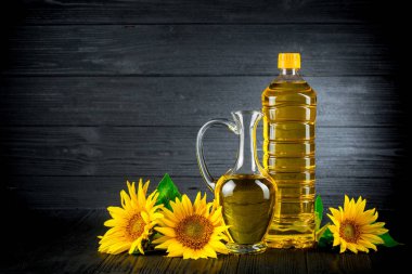 Rustik siyah arka plan üzerine çiçekli ayçiçek yağı