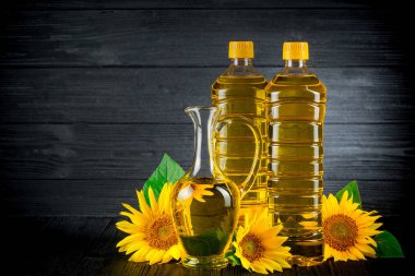 Rustik siyah arka plan üzerine çiçekli ayçiçek yağı
