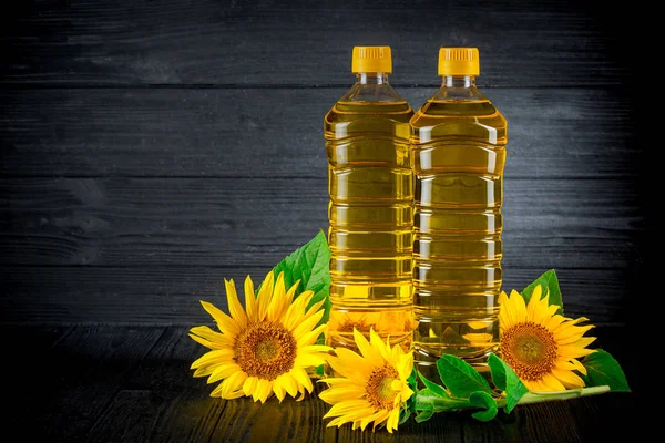 Solrosolja med blommor på svart rustik bakgrund — Stockfoto