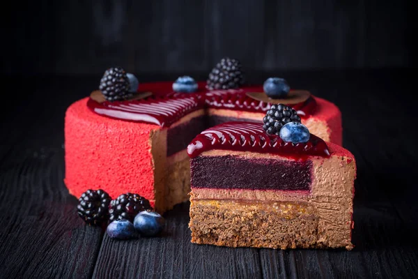 Heerlijke roze taart met bessen op houten tafel — Stockfoto