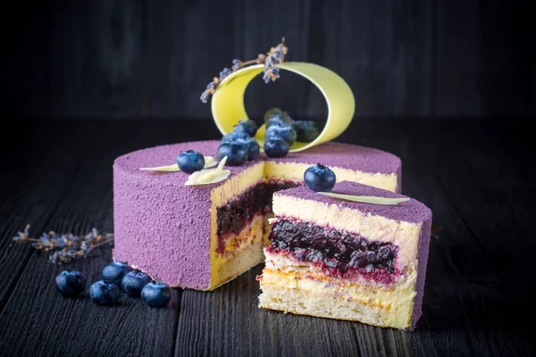 Läcker lavendel kaka med blåbär på träbord — Stockfoto