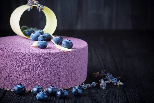 Läcker lavendel kaka med blåbär på träbord — Stockfoto