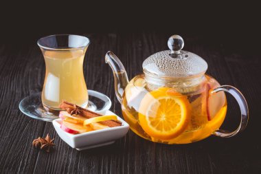 Cam çaydanlık ve bardak siyah arka plan üzerine meyve çayı