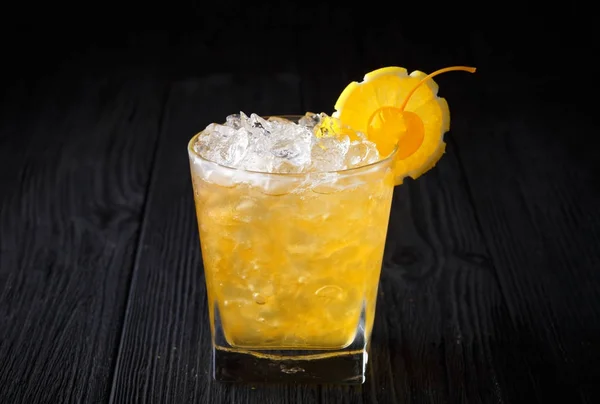 Sarı alkol kokteyl kiraz ve siyah arka plan üzerine limon ile — Stok fotoğraf