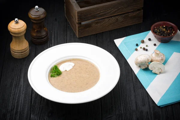 Heerlijke soep puree met champignons op zwarte achtergrond — Stockfoto
