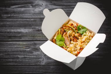 Tavuklu pilav, havuç, mantar ve tatlı biber. Asya yemekleri. Kazanç kutusunda en üstteki görünüm.