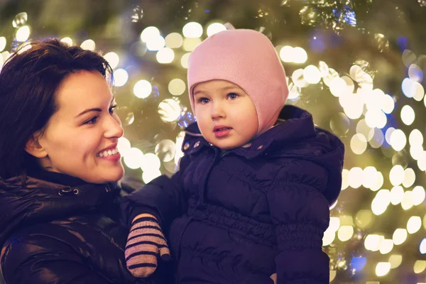 Mother and little daughter over Christmas background — Stock Photo, Image