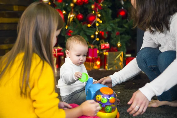 Mladá matka a její dvě děti, otevření vánoční dárky b — Stock fotografie