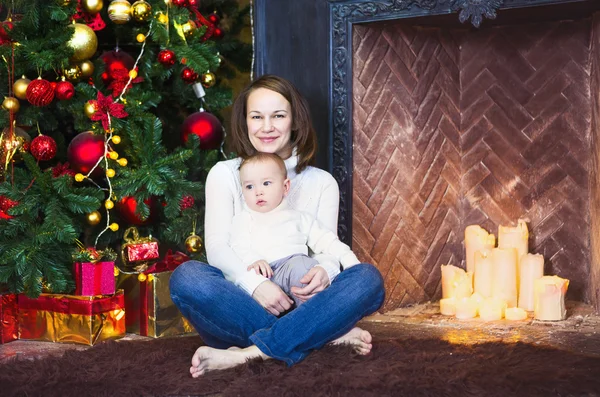 Mamma med hennes pojke lokaliseringen nära julgranen — Stockfoto