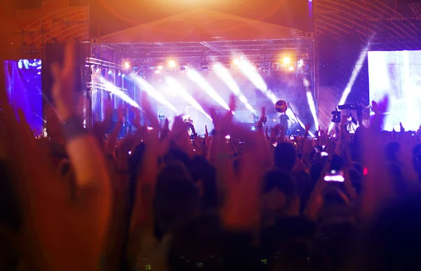 Parlak sahne ışıkları önünde konser kalabalığının siluetleri — Stok fotoğraf