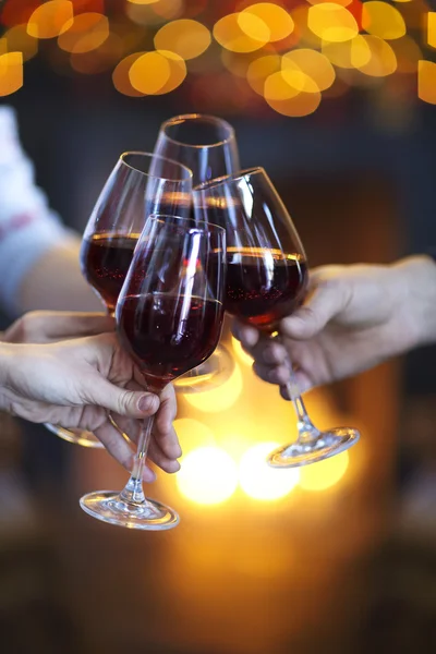 Rammelende glazen wijn in handen op felle lichten achtergrond — Stockfoto