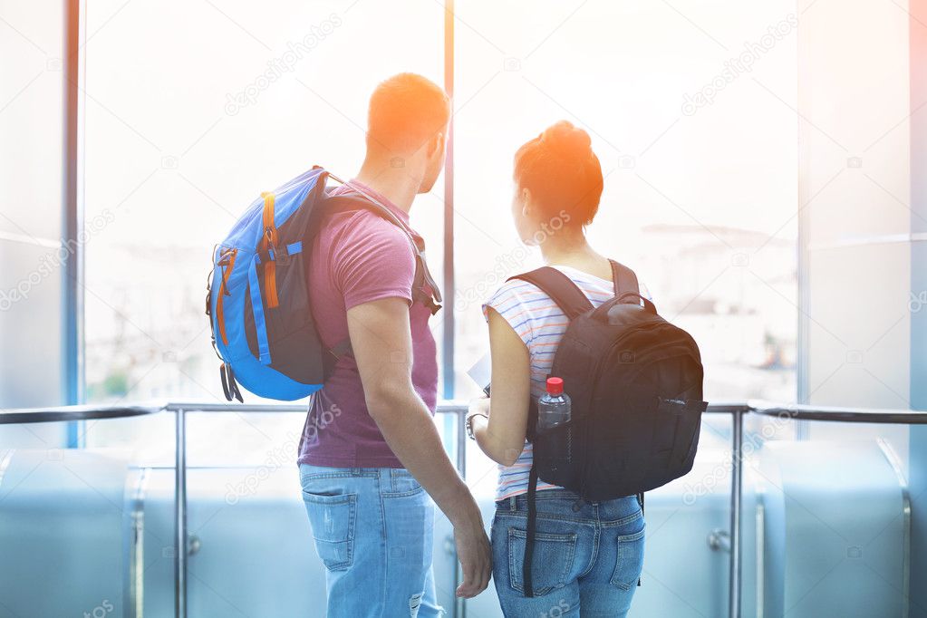 Traveler couple in love with backpacks indoors
