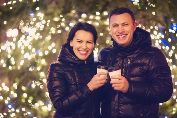 Couple drinking hot beverages at winter holidays — Stock Photo, Image