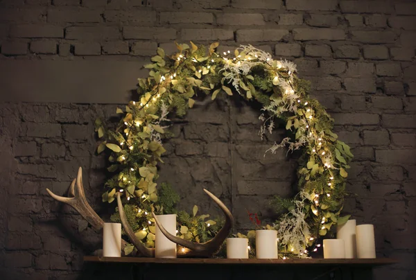 Couronne de Noël au-dessus du manteau sur fond de mur de briques — Photo