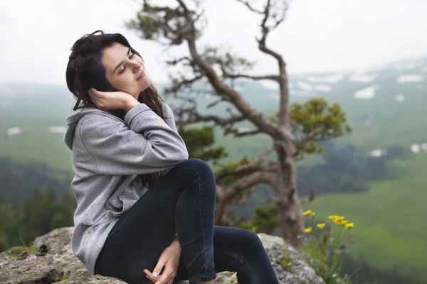 Sognando ragazza si siede sul bordo della scogliera — Foto Stock