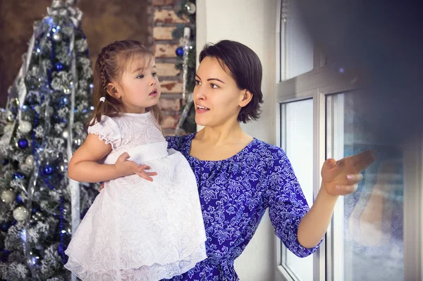 Mãe feliz e sua filhinha junto à árvore de Natal — Fotografia de Stock