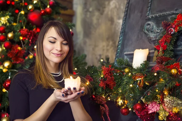 Attractive brunette young woman smiling while holding a burning — Stock Photo, Image