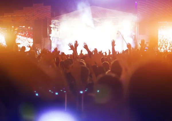 Parlak sahne ışıkları önünde konser kalabalığının siluetleri — Stok fotoğraf