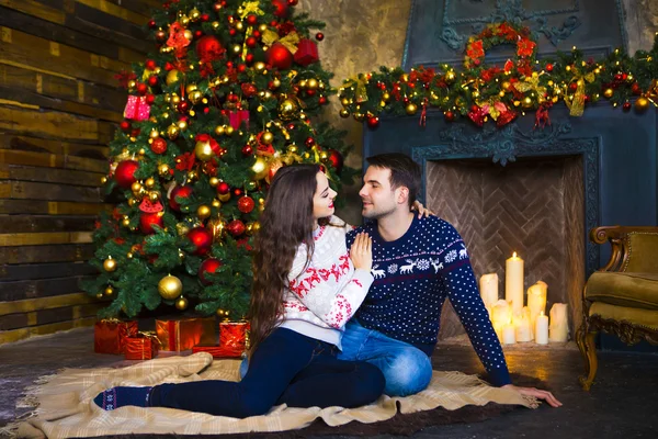 Young couple near fireplace celebrating Christmas — Stock Photo, Image