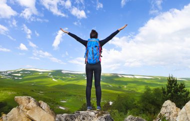 Dağın tepesinde kadın eller yukarı 