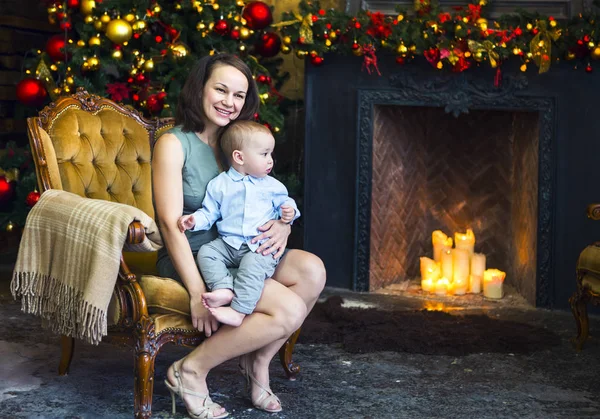クリスマス ツリーの近くに彼女の男の子を持つ母 — ストック写真