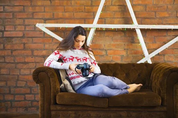 Woman on sofa with photo camera — Stock Photo, Image