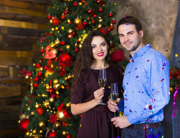 Молодая пара у камина празднует Рождество — стоковое фото