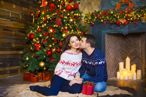 Casal jovem perto da lareira celebrando o Natal — Fotografia de Stock