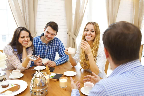 Groep vier gelukkige vrienden ontmoeten, praten en eten desse — Stockfoto