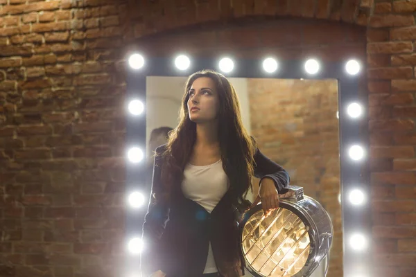 Jonge vrouw poseren in de buurt van de spiegel — Stockfoto