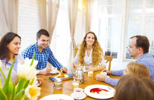 Amigos felices conociendo y hablando y comiendo postres en una mesa —  Fotos de Stock