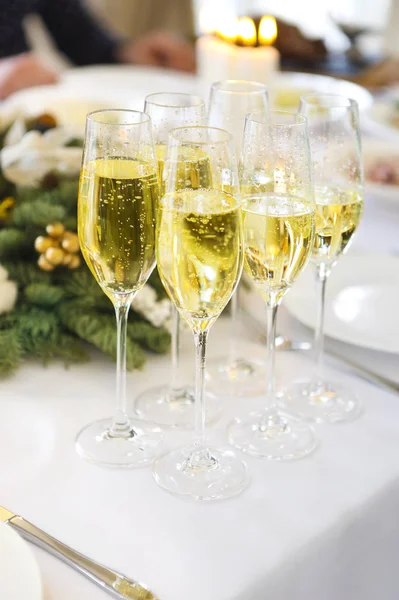 Champagne in bicchieri in piedi sulla tavola di Natale — Foto Stock
