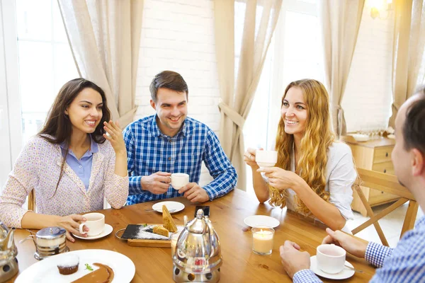 Grupo de cuatro amigos felices conociendo y hablando y comiendo desse —  Fotos de Stock