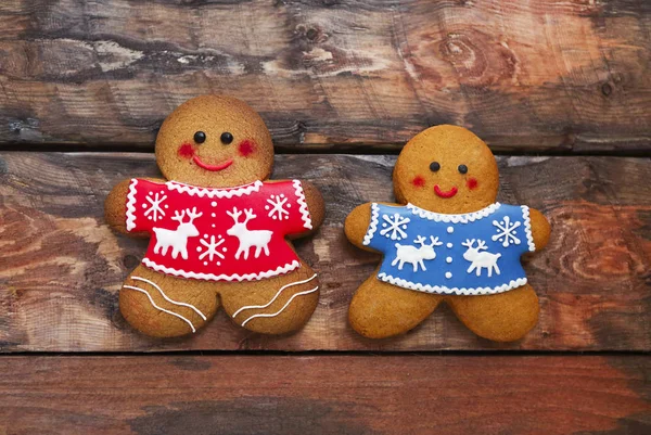 Hombres de jengibre de Navidad sonrientes sobre fondo de madera . — Foto de Stock