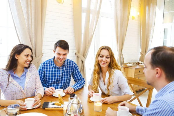 Grupo de cuatro amigos felices conociendo y hablando y comiendo desse —  Fotos de Stock