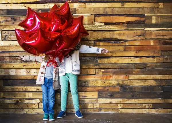 Niños con globos en la pared de madera — Foto de Stock